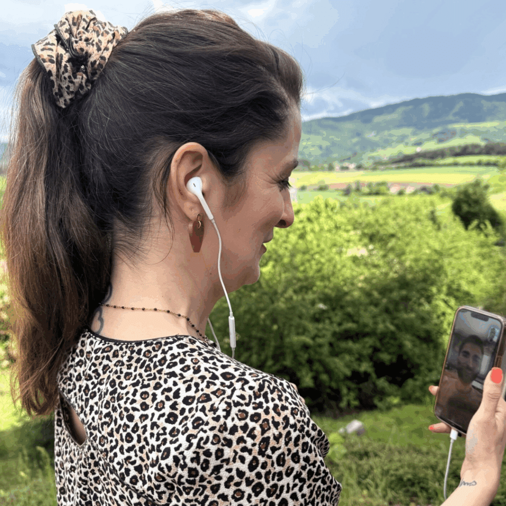 Femme en visioconférence avec son coach minceur en ligne depuis l’extérieur, avec écouteurs et smartphone